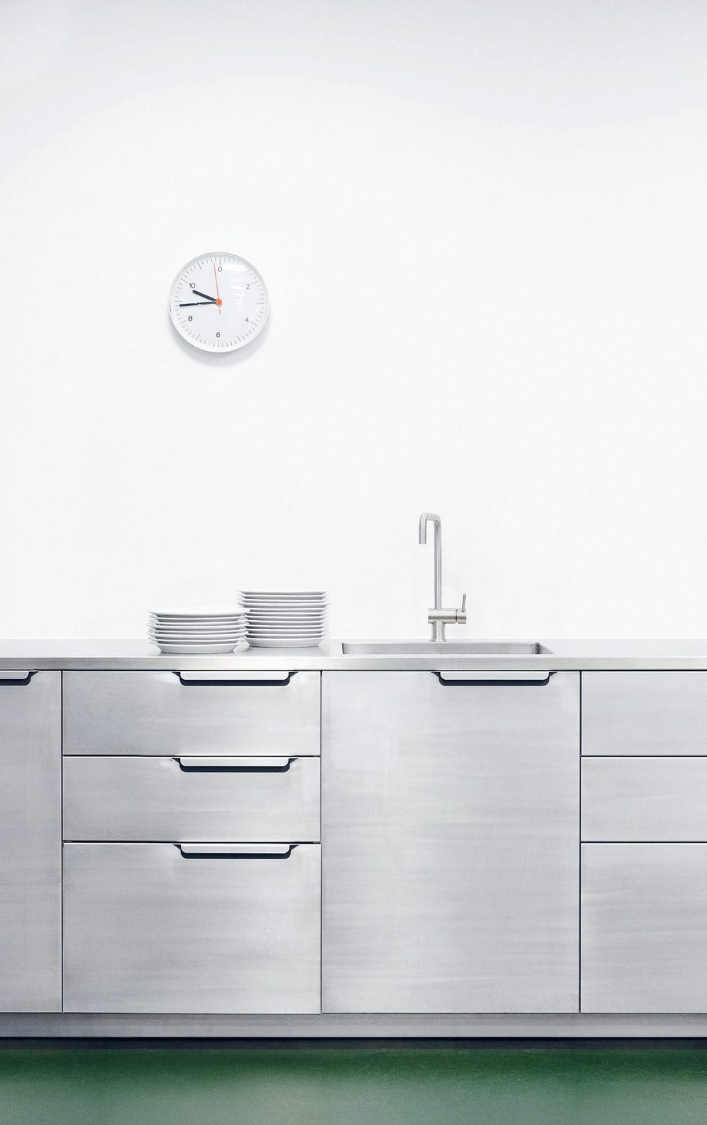 Fronts and handles in raw, brushed aluminum · Stainless steel counterto
