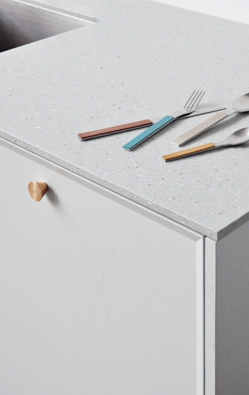 Painted fronts in light blue · Handles in brass · Countertop in Corian Fossil