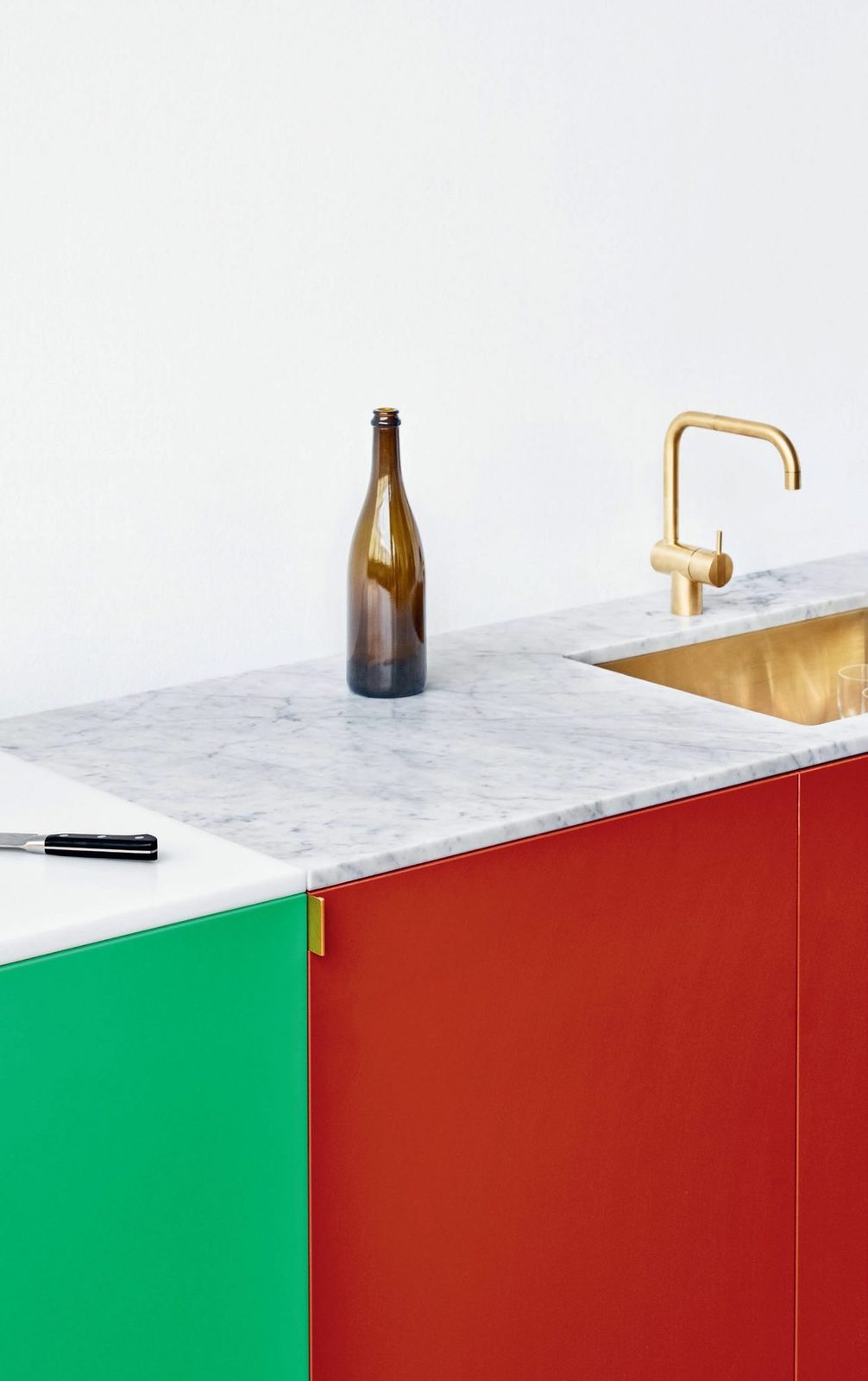 HDPE fronts in green and red · Handles in the color Satin Gold · Countertop in mar