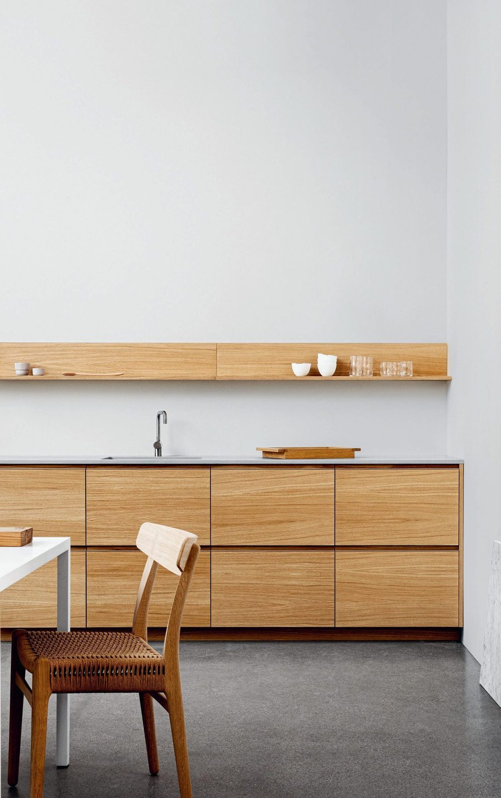 Fronts and shelves in natural oak · Integrated aluminum handles · Dekton countert
