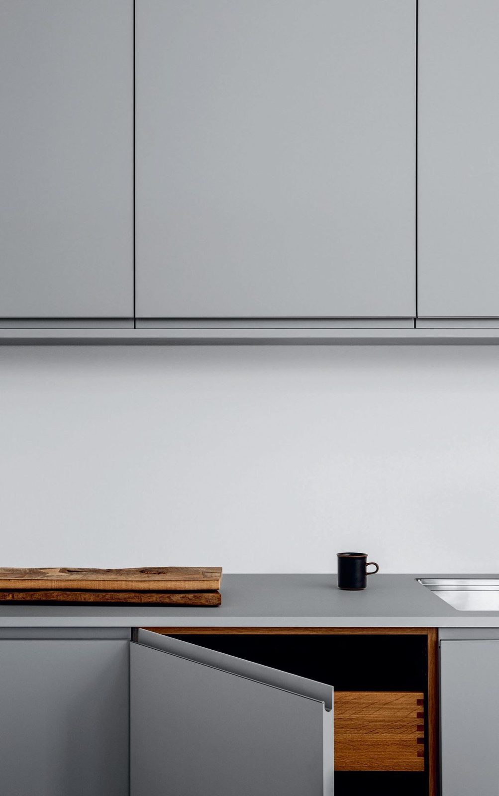 Painted fronts in gray · Integrated aluminum handles · Dekton counterto